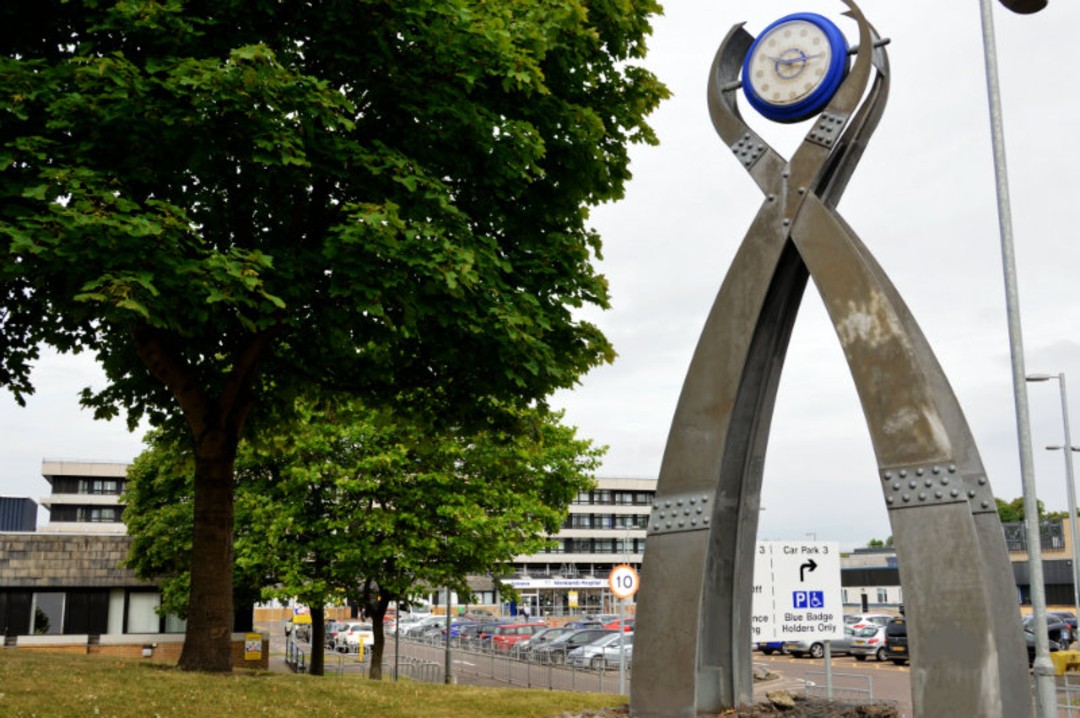 large metal sculpture with rotary clock at the top