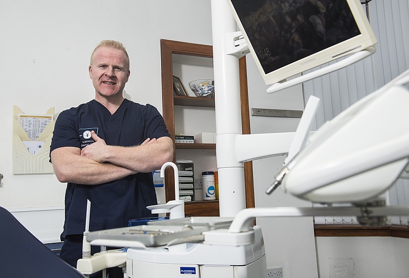 Dental expert David McIntyre standing next to a dentists chair