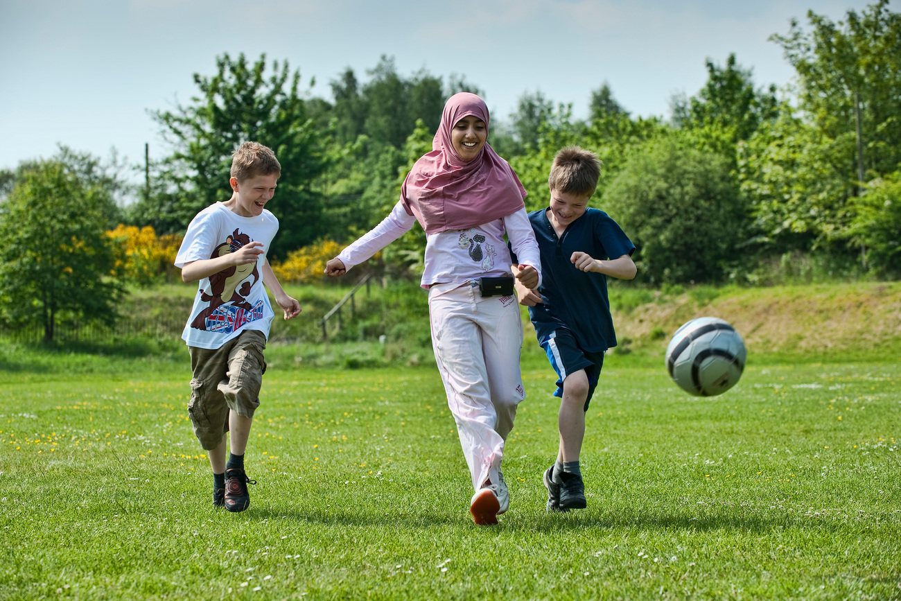 Three children playing with a football