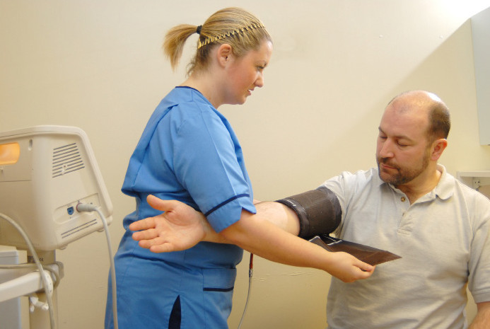 nurse putting cuff on an arm