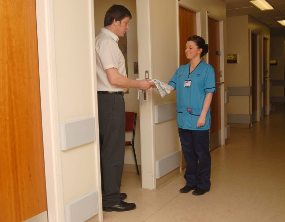 A person putting on a hospital gown