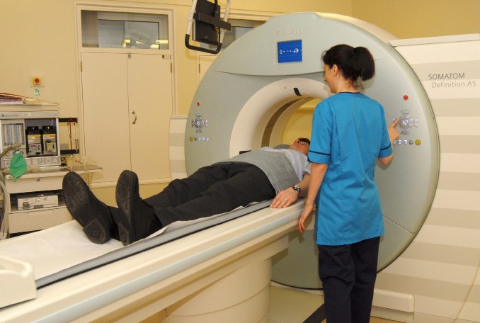 a CT machine sliding a person through on a trolley