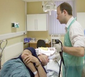 a doctor putting a camera gently down a patient's throat