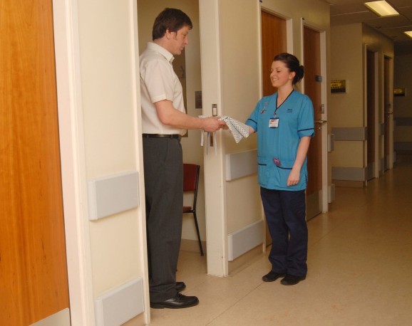 nurse handing a patient a gown
