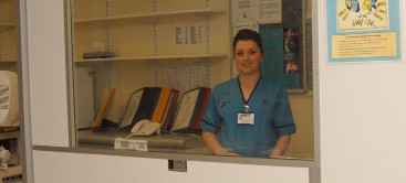 radiographer standing behind a screen