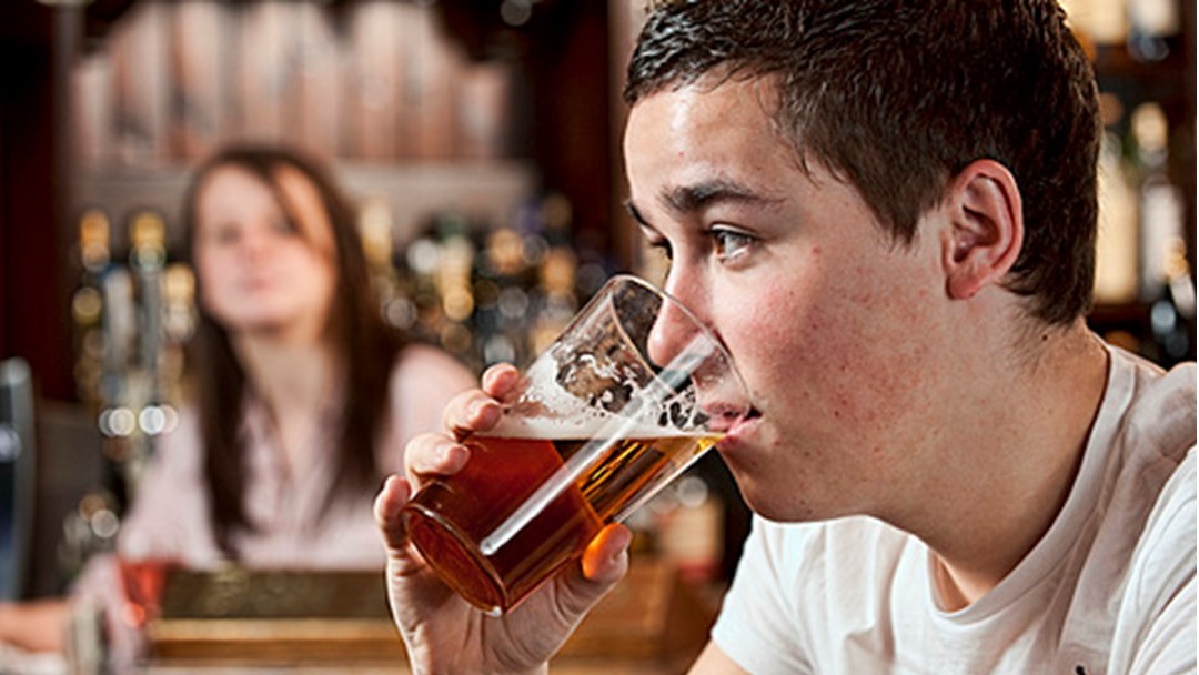 Image of young male drinking pint of beer