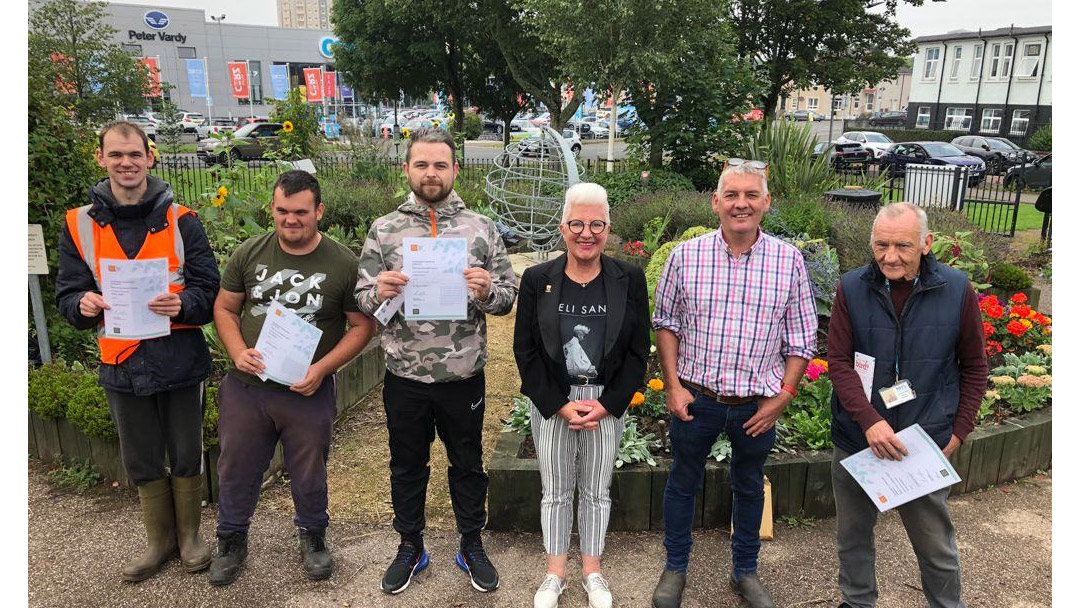 CCI volunteers with certificates in garden