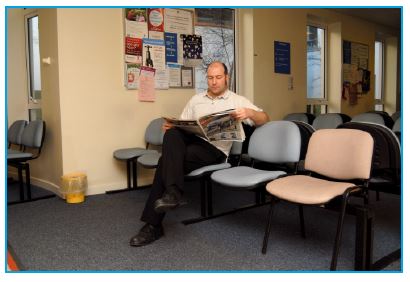 patient reading a newspaper in a waiting room