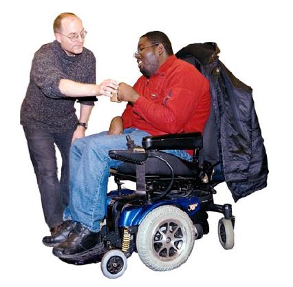 person in a wheelchair drinking from a mug