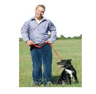 man and a dog standing in a field