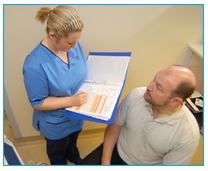 nurse writing down what pills were taken