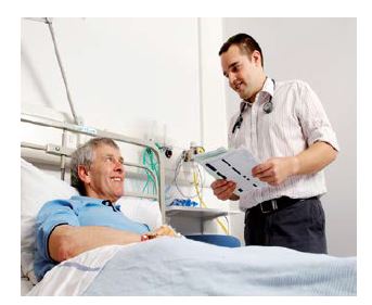 man in a hospital bed talking to a doctor