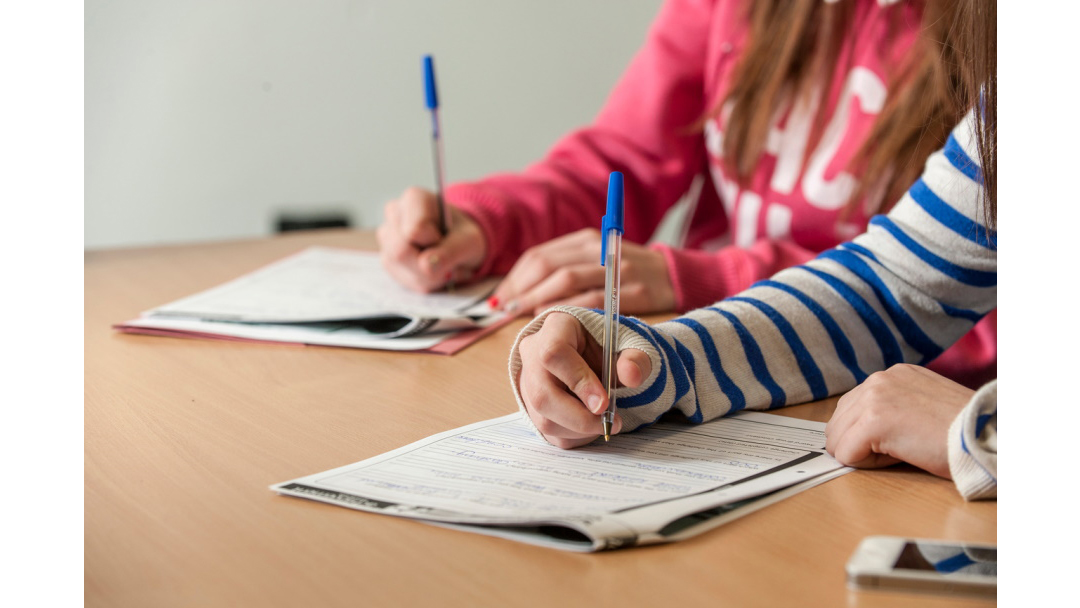 2 note pads with someone holding pen and writing