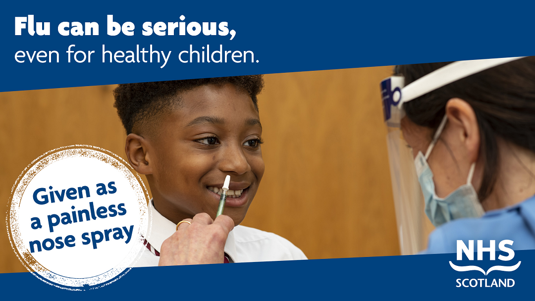 Photo of a young boy receiving a nasal spray vaccine by a nurse in a mask and face screen. Flu can be serious, even for healthy children. Given as a painless nose spray. NHS Scotland.