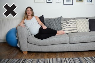 Diagram of a pregnant woman sitting incorrectly on the sofa