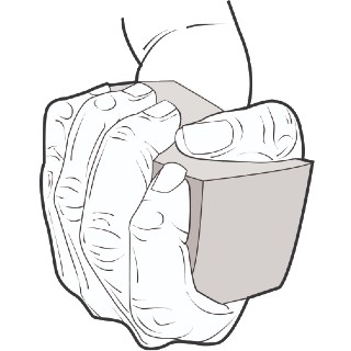 Upturned fist squeezing a block as a hand therapy exercise