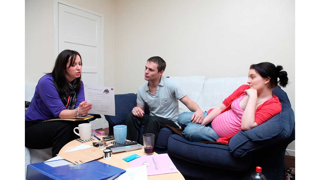 Pregnant woman with partner and health professional