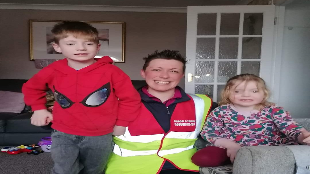 a woman, little boy and little girl are smiling at the camera
