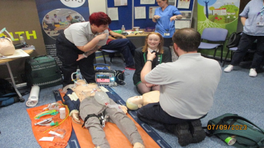 Young people learning from professionals simulating medical situations