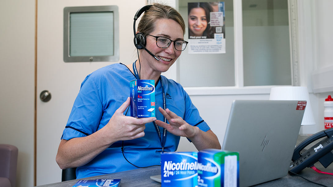 Nurse holding nicotine replacement gum and talking on a face-to-face online call
