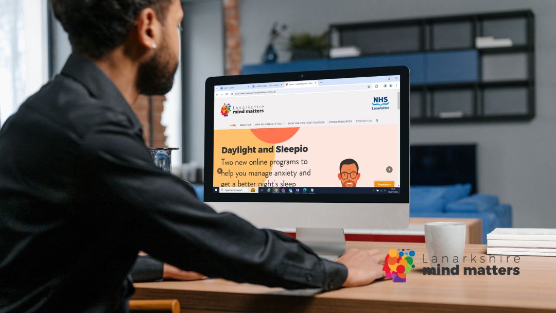 Man looking at Lanarkshire Mind Matters website on a desktop screen